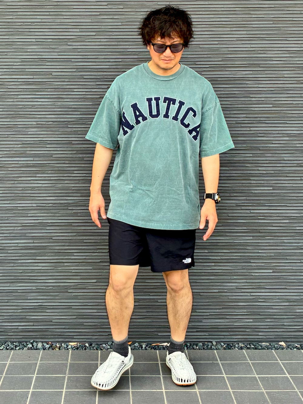 グリーン系のTシャツ/カットソー、ブラック系のその他パンツ、ホワイト系のサンダルを着用したメンズの夏コーディネートの3枚目の写真