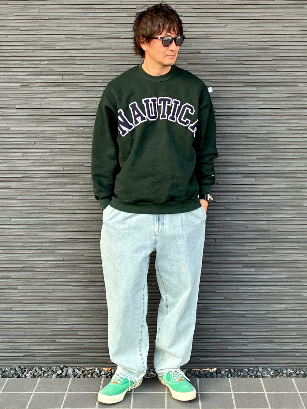 グリーン系のスウェット、ブルー系のデニムパンツ、グリーン系のスニーカーを着用したメンズの春コーディネートの3枚目の写真