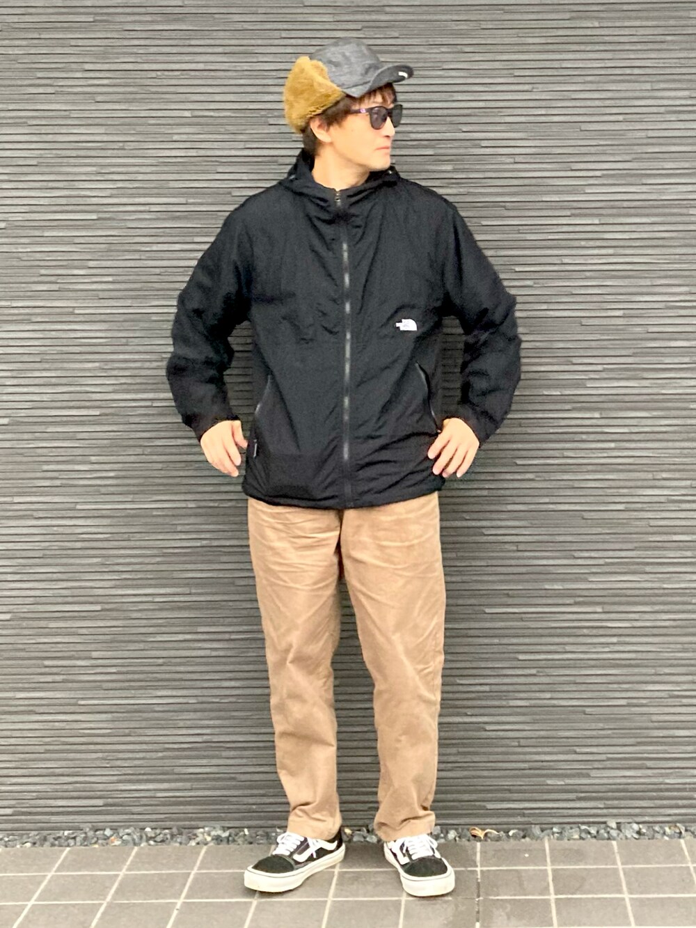 ブラック系のナイロンジャケット、ブラウン系のその他パンツ、ブラック系のスニーカーを着用したメンズの冬コーディネートの3枚目の写真