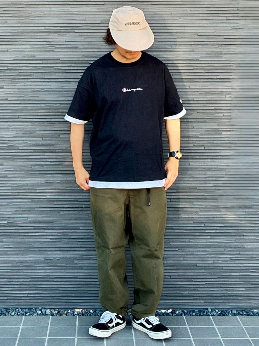 グリーン系のチノパンツ、ブラック系のスニーカー、ブラック系のTシャツ/カットソーを着用したメンズの夏コーディネートの3枚目の写真