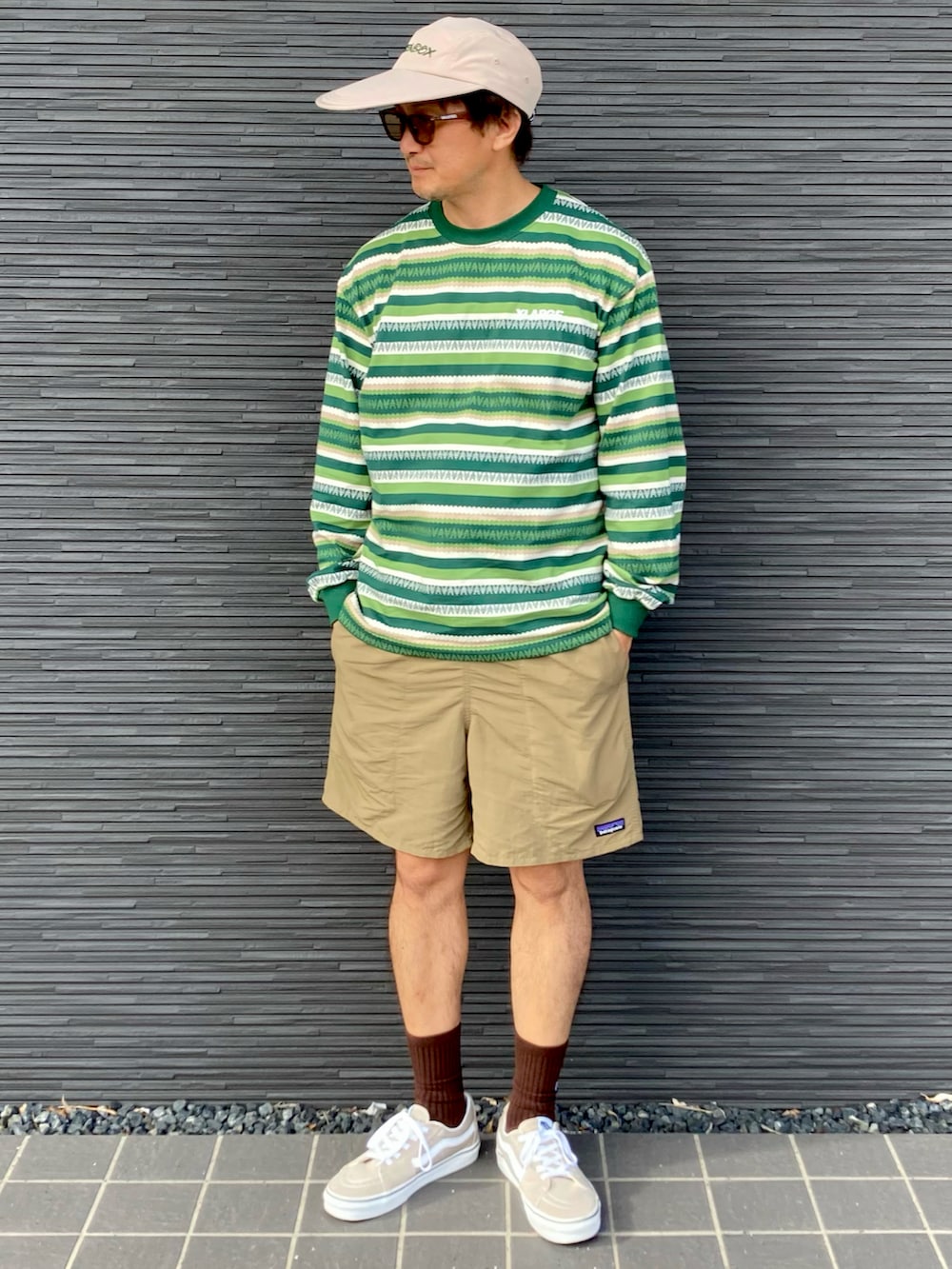 ベージュ系のその他パンツ、グリーン系のTシャツ/カットソー、ベージュ系のスニーカーを着用したメンズの秋コーディネートの3枚目の写真