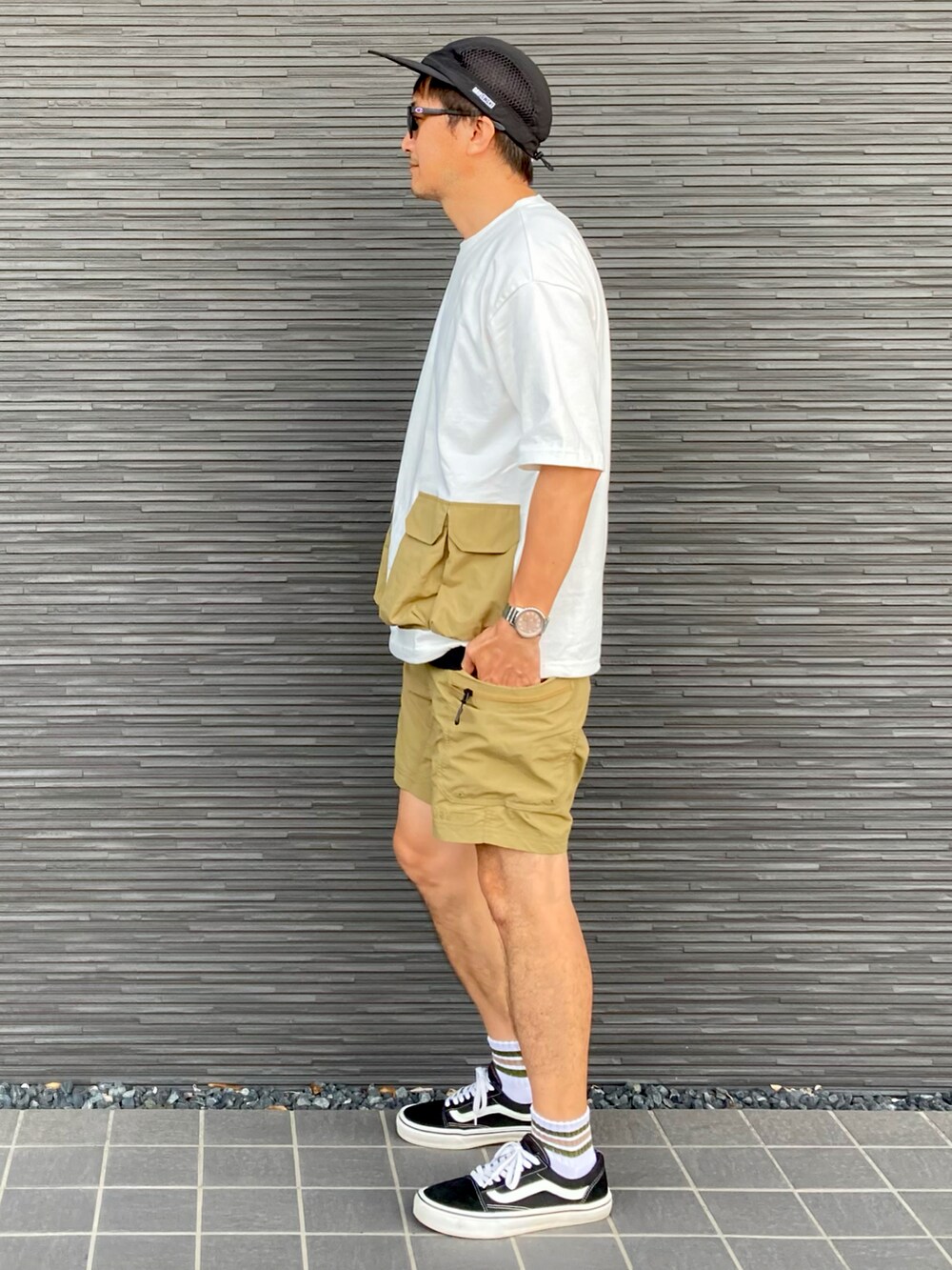 ホワイト系のTシャツ/カットソー、ベージュ系のその他パンツ、ブラック系のスニーカーを着用したメンズの夏コーディネートの3枚目の写真