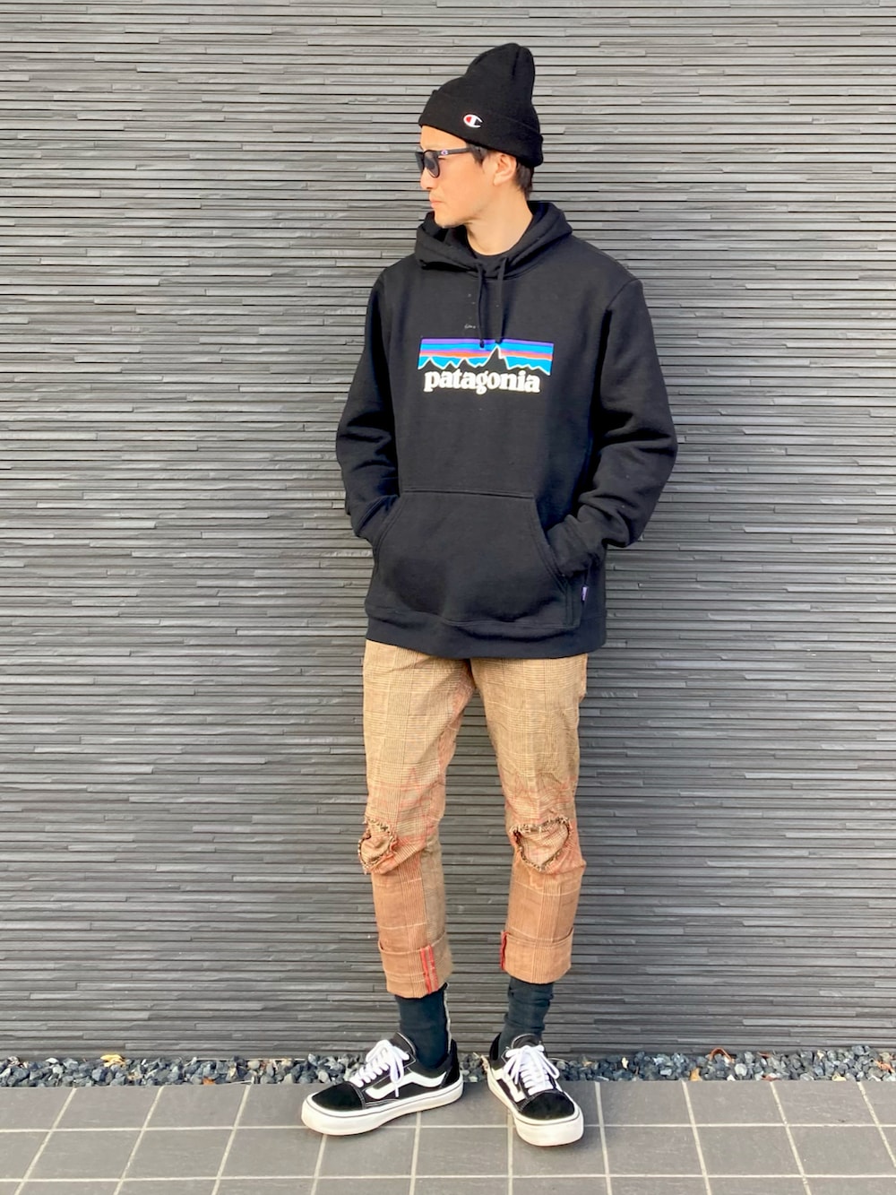 ブラック系のパーカー、ブラウン系のパンツ、ブラック系のスニーカーを着用したメンズの春コーディネートの2枚目の写真