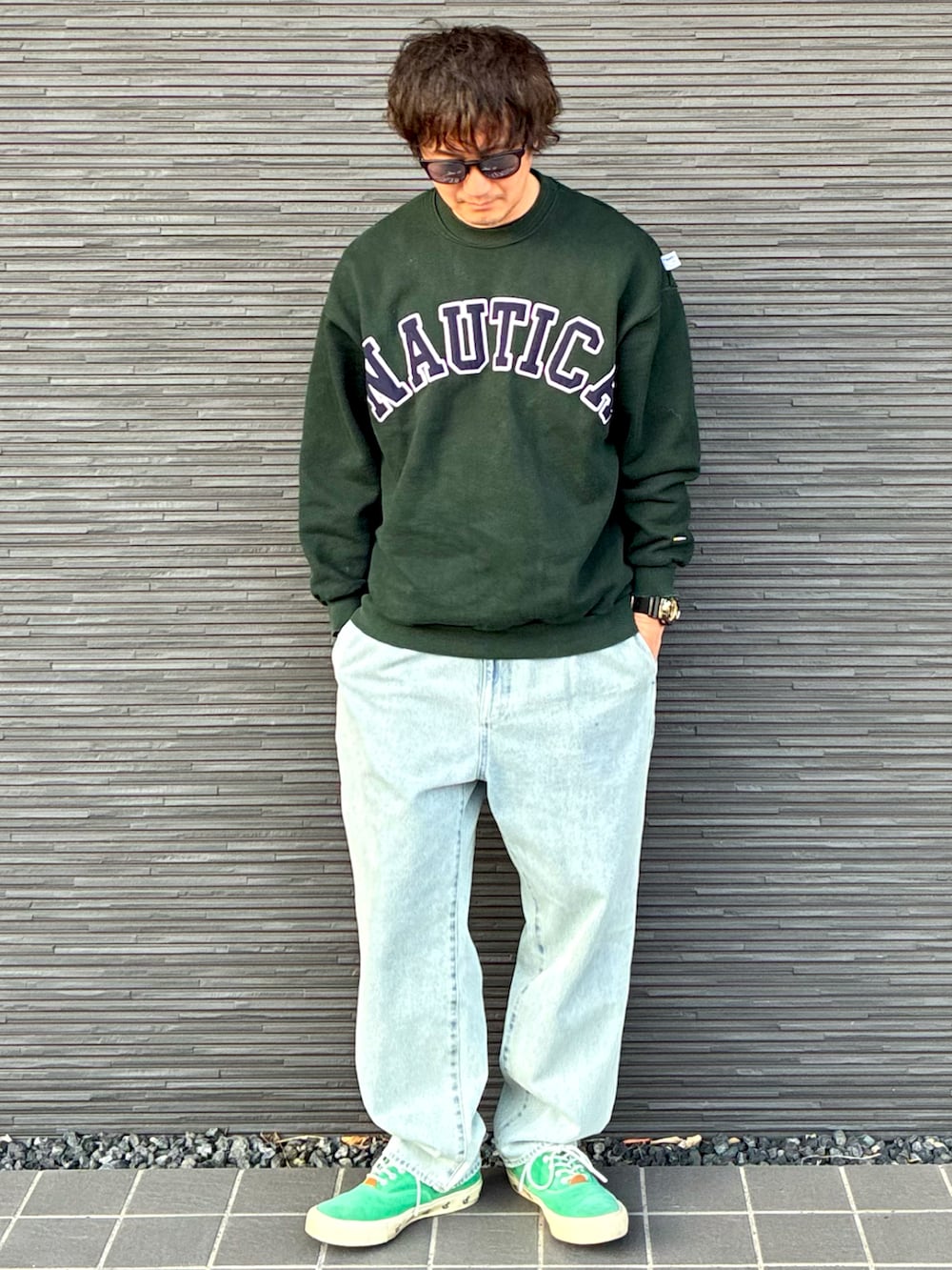 グリーン系のスウェット、ブルー系のデニムパンツ、グリーン系のスニーカーを着用したメンズの春コーディネートの2枚目の写真