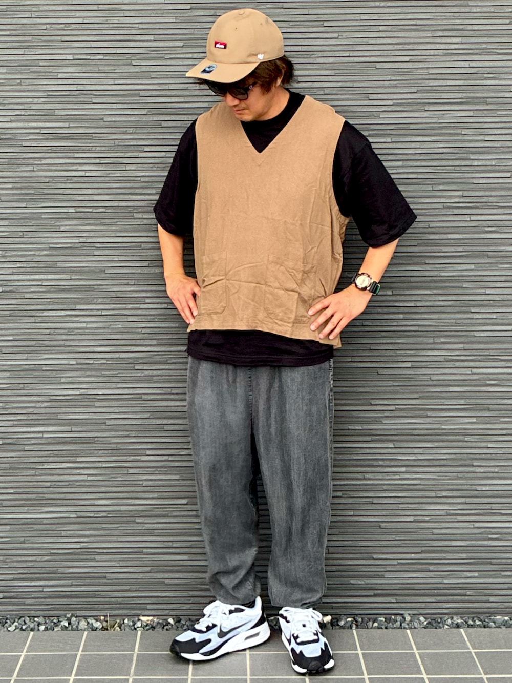 ブラック系のTシャツ/カットソー、ベージュ系のベスト、ブラック系のその他パンツを着用したメンズの秋コーディネートの2枚目の写真