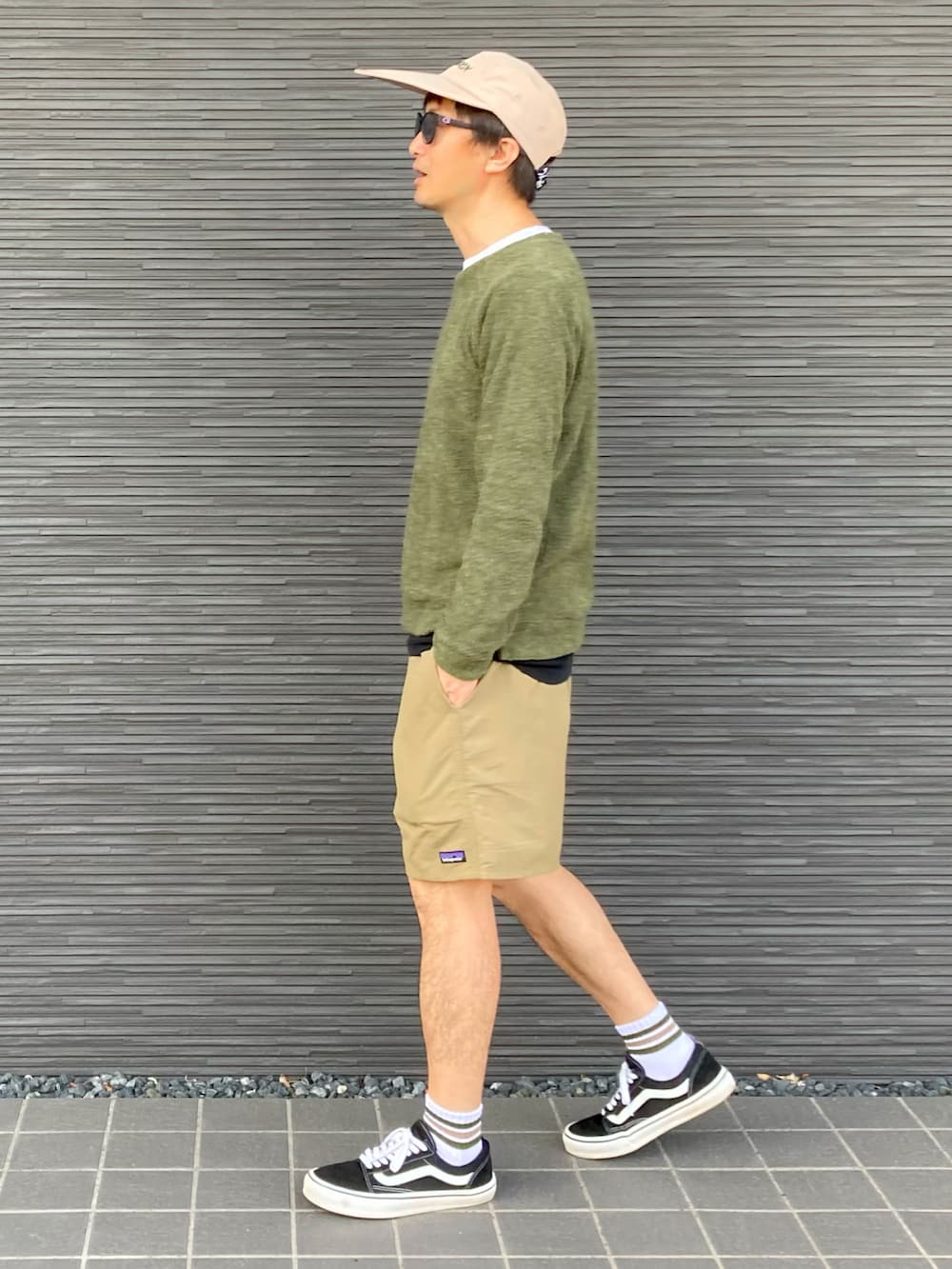 グリーン系のニット/セーター、ホワイト系のTシャツ/カットソー、ブラック系のTシャツ/カットソーを着用したメンズの春コーディネートの3枚目の写真