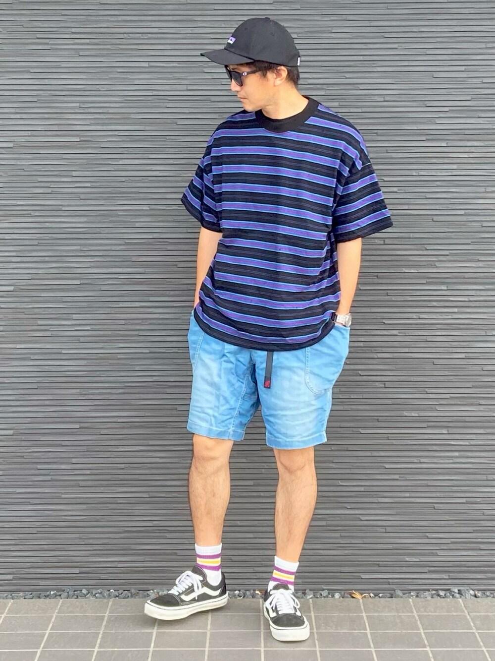 ブラック系のTシャツ/カットソー、ブルー系のデニムパンツ、ブラック系のスニーカーを着用したメンズの夏コーディネートの2枚目の写真