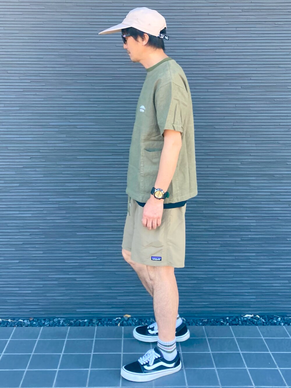 ブラック系のスニーカー、ベージュ系のその他パンツ、グリーン系のTシャツ/カットソーを着用したメンズの夏コーディネートの4枚目の写真