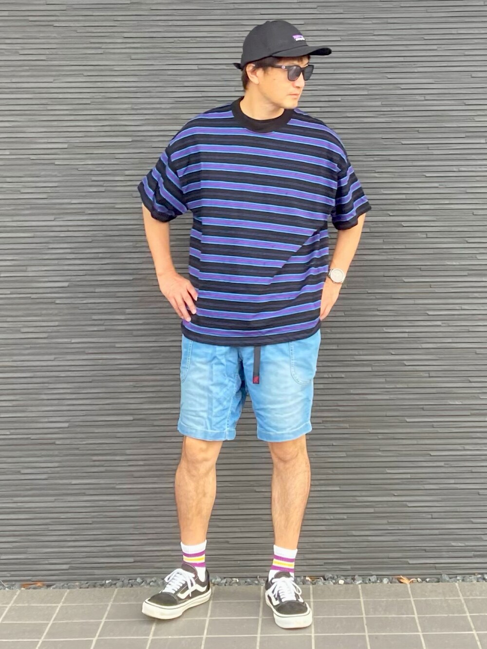 ブラック系のTシャツ/カットソー、ブルー系のデニムパンツ、ブラック系のスニーカーを着用したメンズの夏コーディネートの3枚目の写真