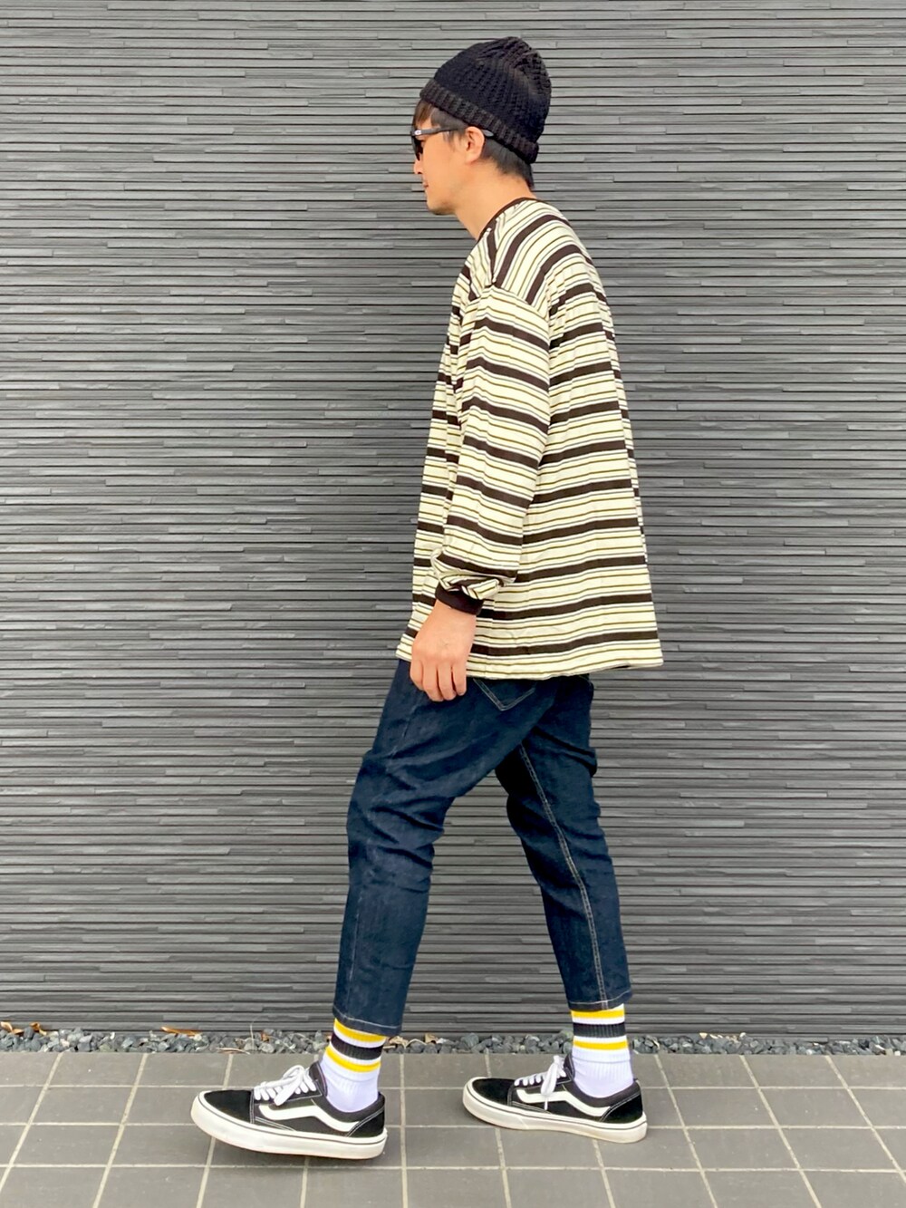 ブラック系のTシャツ/カットソー、ブルー系のデニムパンツ、ブラック系のスニーカーを着用したメンズの秋コーディネートの2枚目の写真