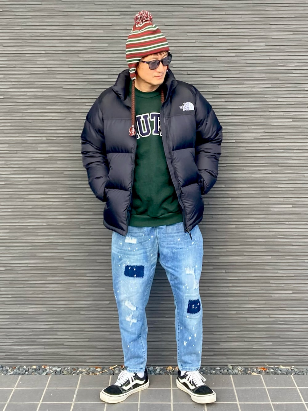 ブラック系のダウンジャケット/コート、グリーン系のスウェット、ブルー系のデニムパンツを着用したメンズの冬コーディネートの3枚目の写真