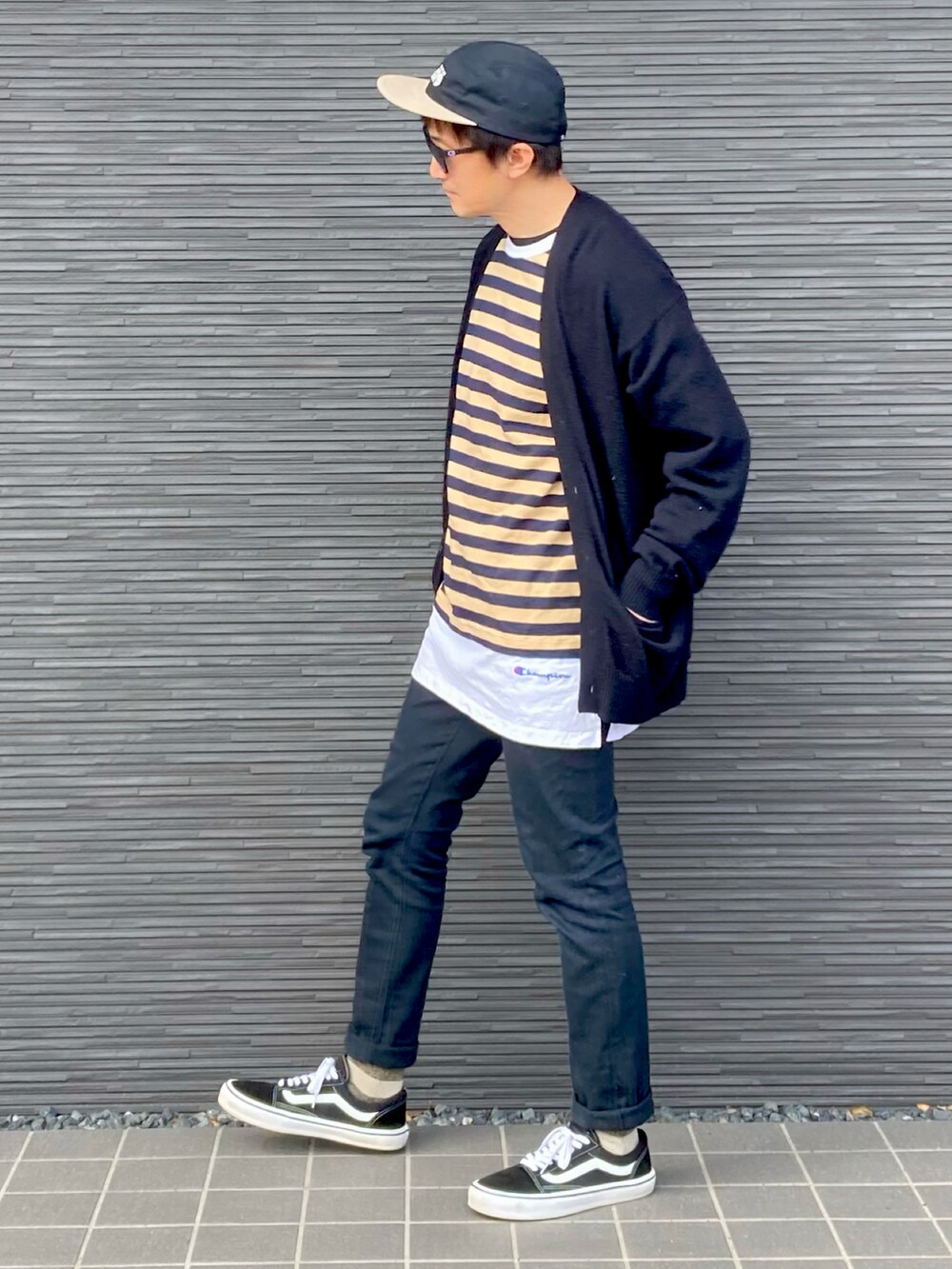 ブラック系のトップス、イエロー系のTシャツ/カットソー、ブラック系のパンツを着用したメンズの春コーディネートの2枚目の写真