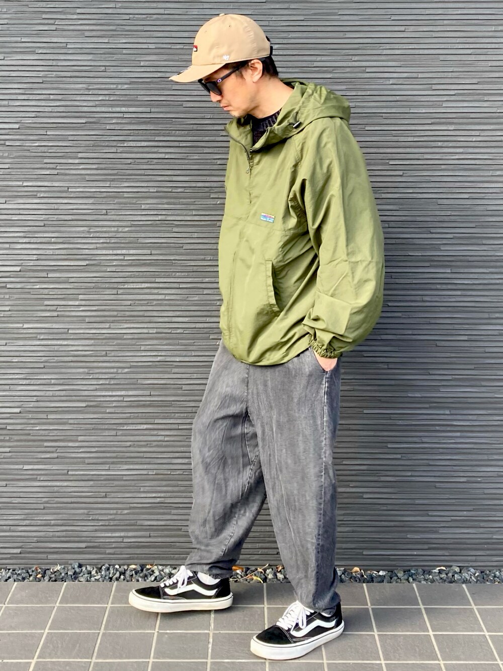 グリーン系のナイロンジャケット、ブラック系のニット/セーター、ブラック系のその他パンツを着用したメンズの春コーディネートの3枚目の写真