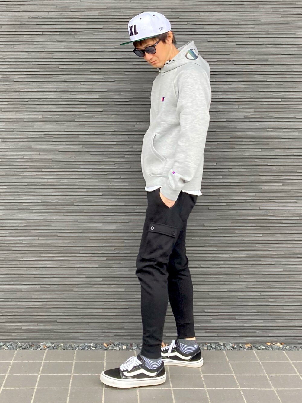 グレー系のパーカー、ホワイト系のTシャツ/カットソー、ブラック系のスウェットパンツを着用したメンズの春コーディネートの2枚目の写真
