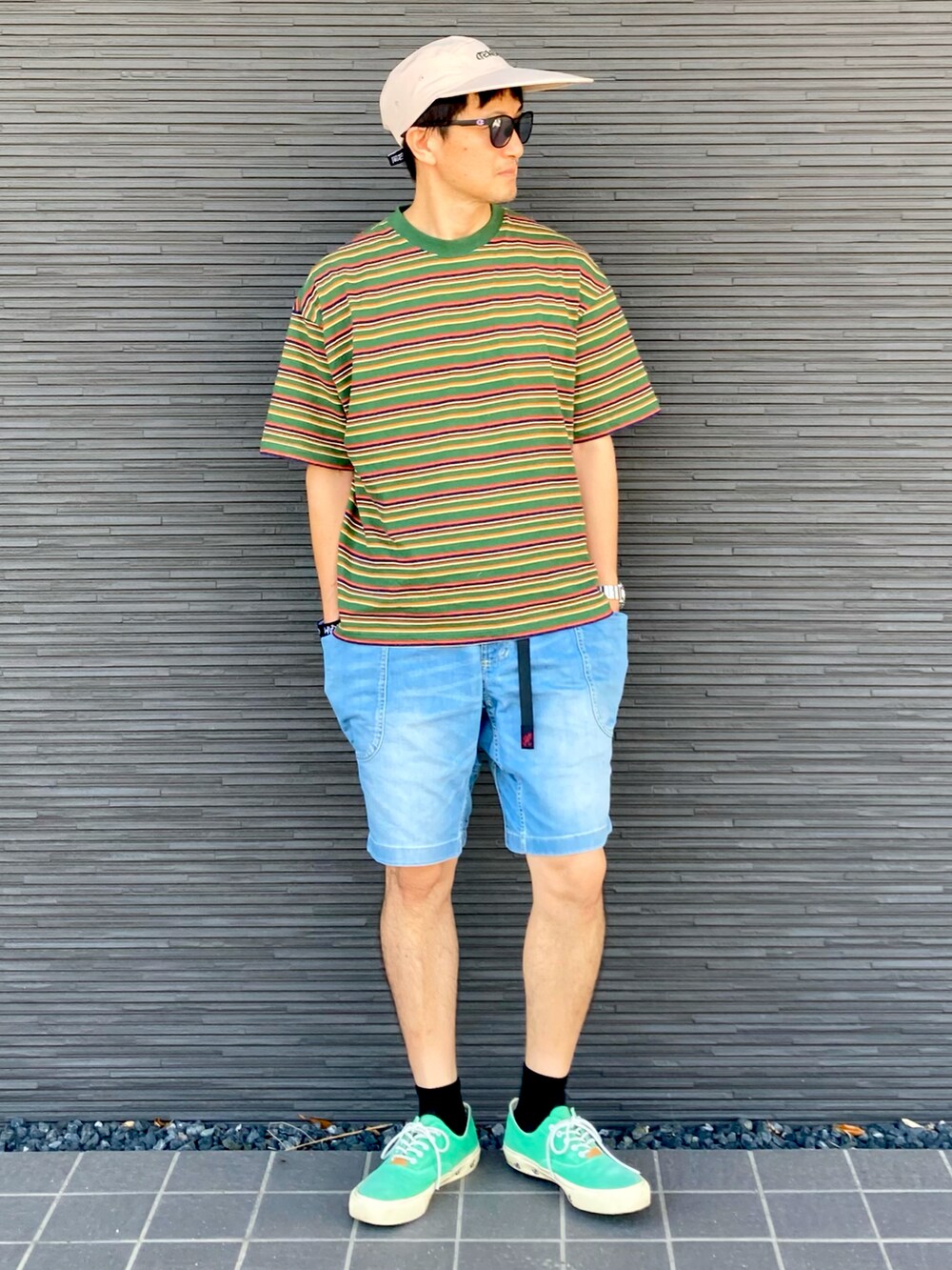 グリーン系のTシャツ/カットソー、ブルー系のデニムパンツ、グリーン系のスニーカーを着用したメンズの夏コーディネートの2枚目の写真