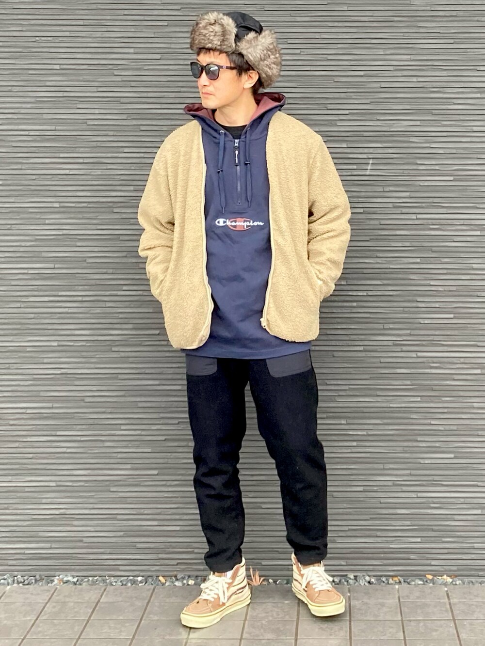 ベージュ系のノーカラージャケット、ブラック系のパーカー、ブラック系のパンツを着用したメンズの冬コーディネートの2枚目の写真