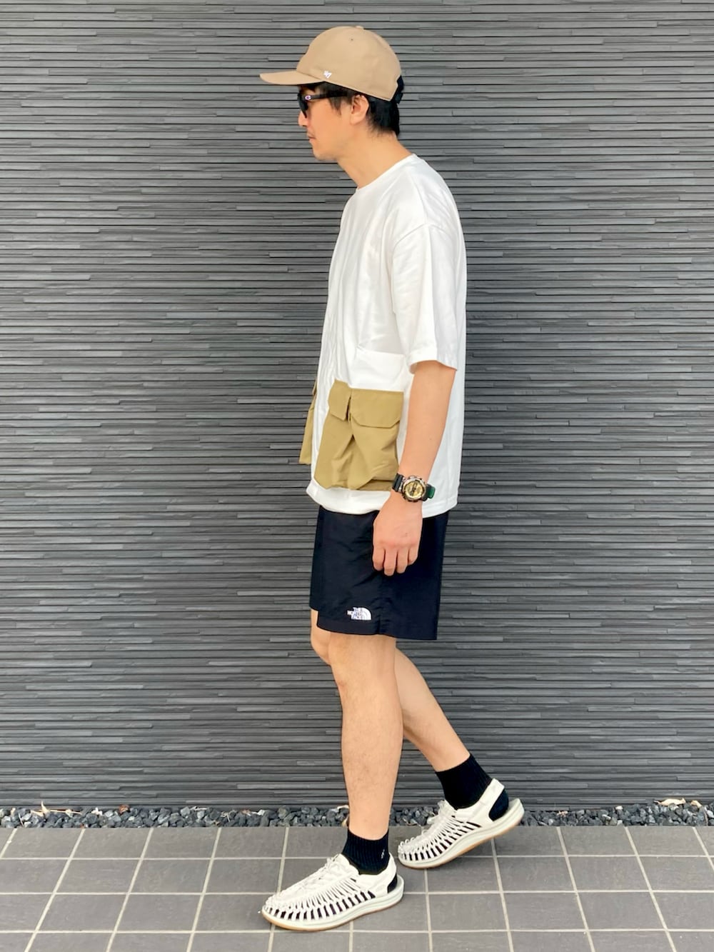 ホワイト系のTシャツ/カットソー、ブラック系のその他パンツ、ホワイト系のサンダルを着用したメンズの夏コーディネートの3枚目の写真