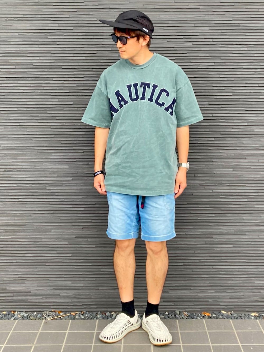 グリーン系のTシャツ/カットソー、ブルー系のデニムパンツ、ホワイト系のサンダルを着用したメンズの夏コーディネートの2枚目の写真