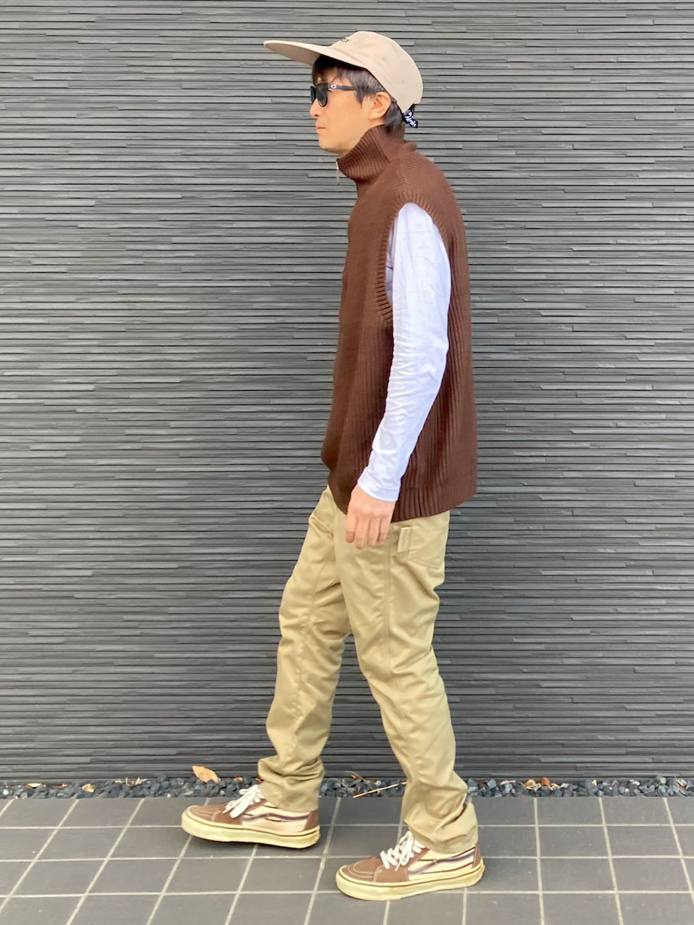 ブラウン系のベスト、ホワイト系のTシャツ/カットソー、ベージュ系のチノパンツを着用したメンズの春コーディネートの2枚目の写真