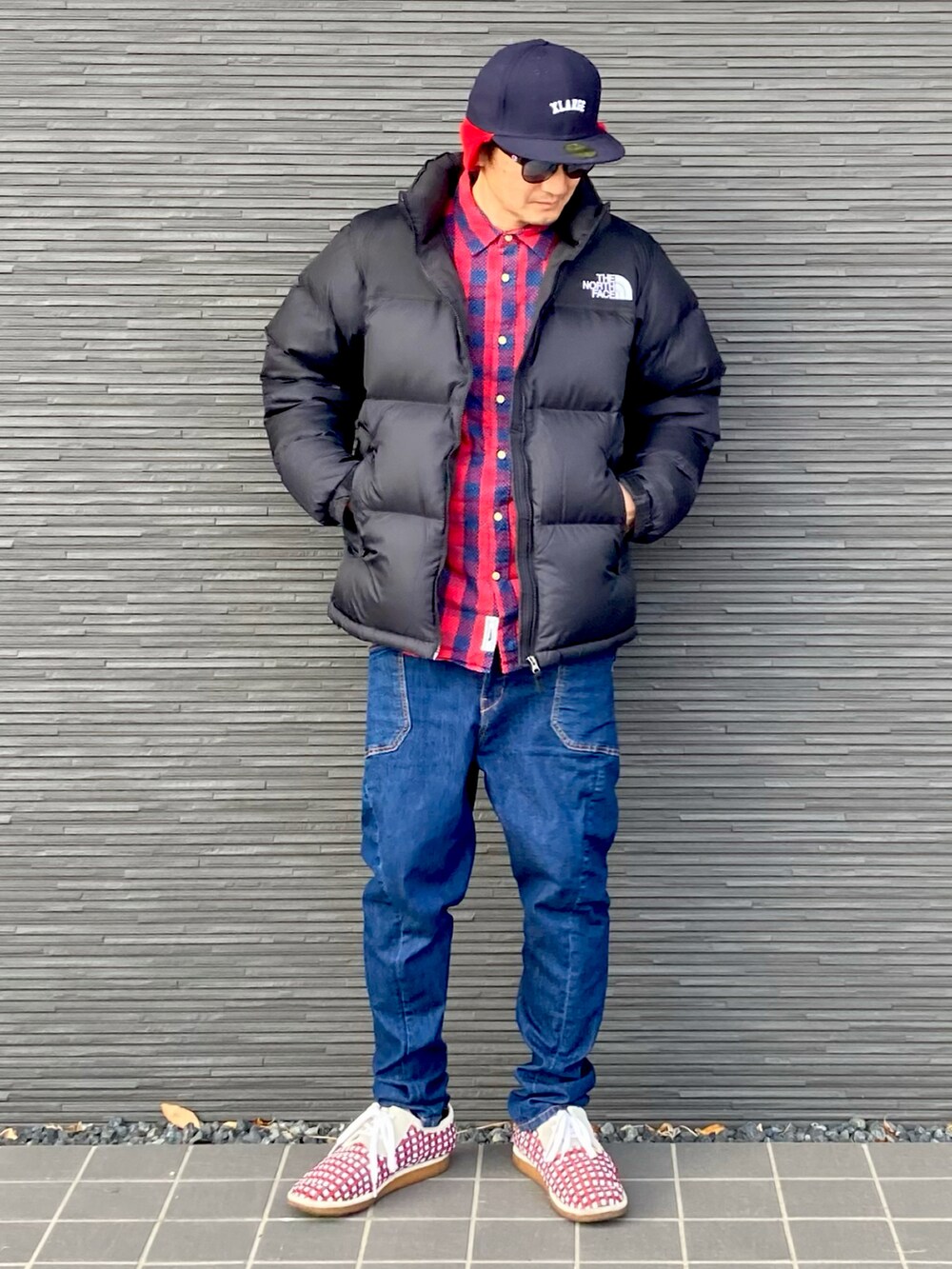 ブラック系のダウンジャケット/コート、レッド系のシャツ/ブラウス、ブルー系のカーゴパンツを着用したメンズの冬コーディネートの2枚目の写真