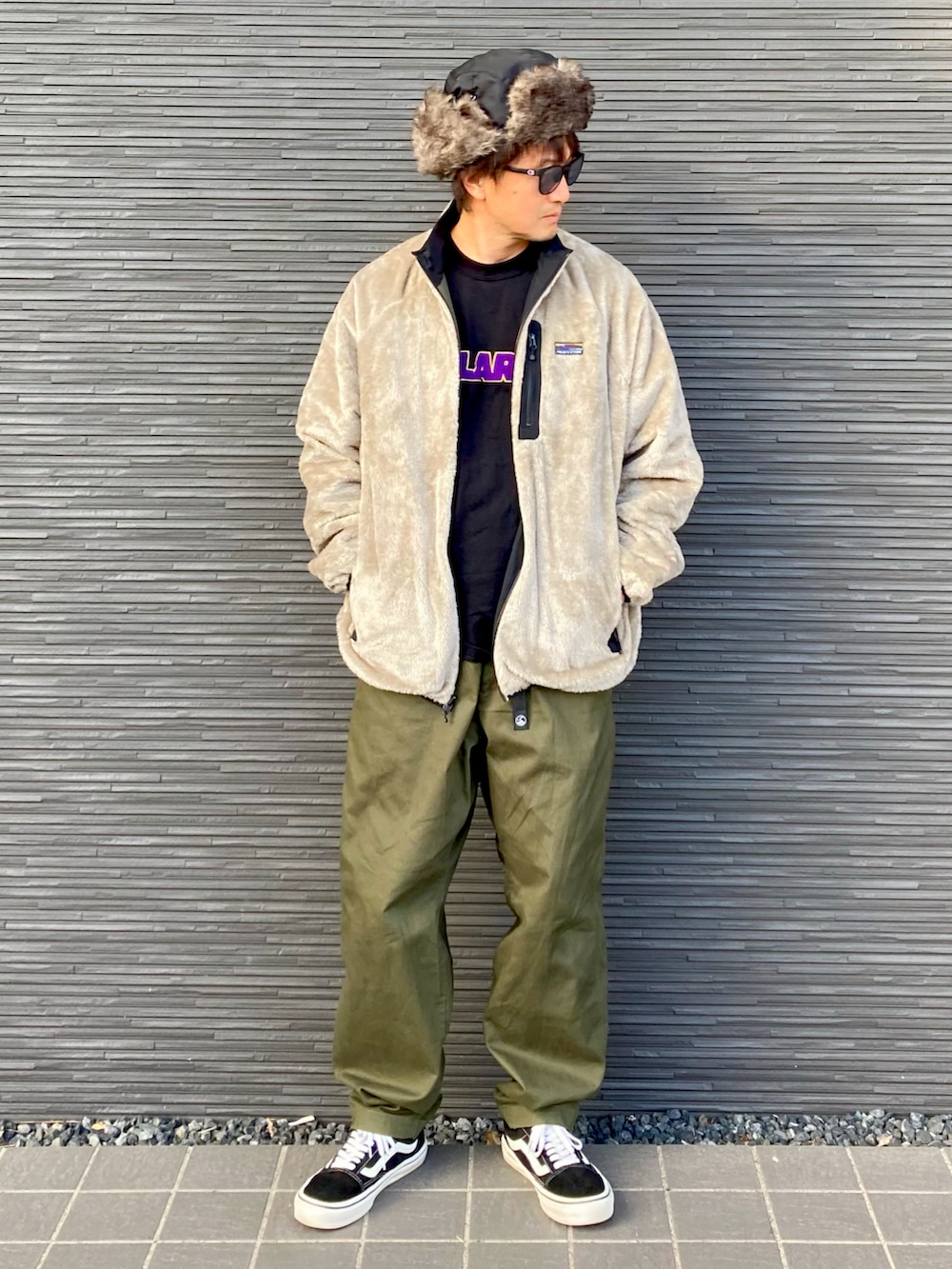 その他のナイロンジャケット、ブラック系のTシャツ/カットソー、グリーン系のチノパンツを着用したメンズの冬コーディネートの2枚目の写真