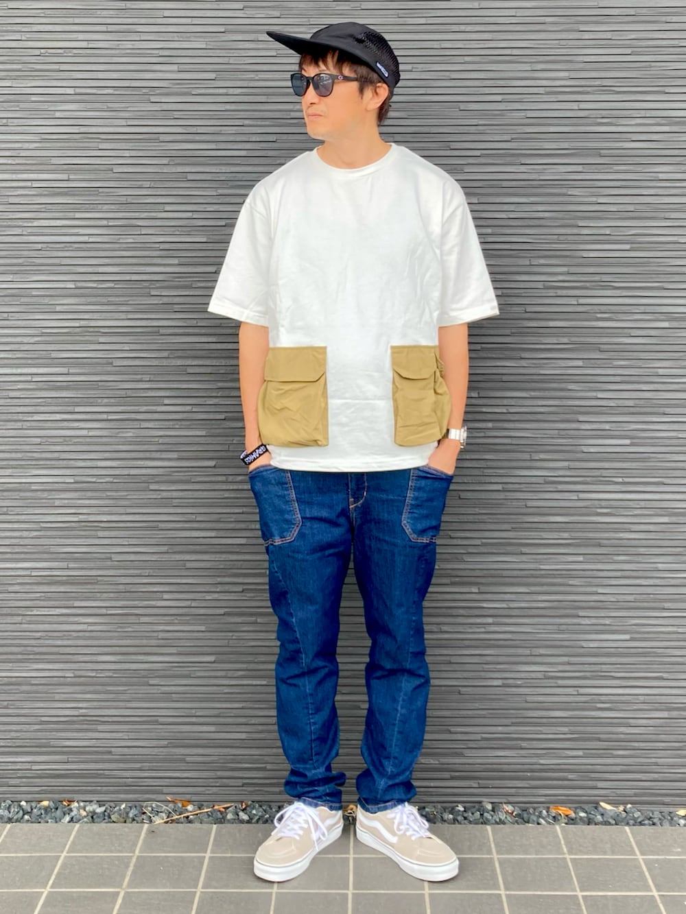 ホワイト系のTシャツ/カットソー、ブルー系のカーゴパンツ、ベージュ系のスニーカーを着用したメンズの夏コーディネートの2枚目の写真