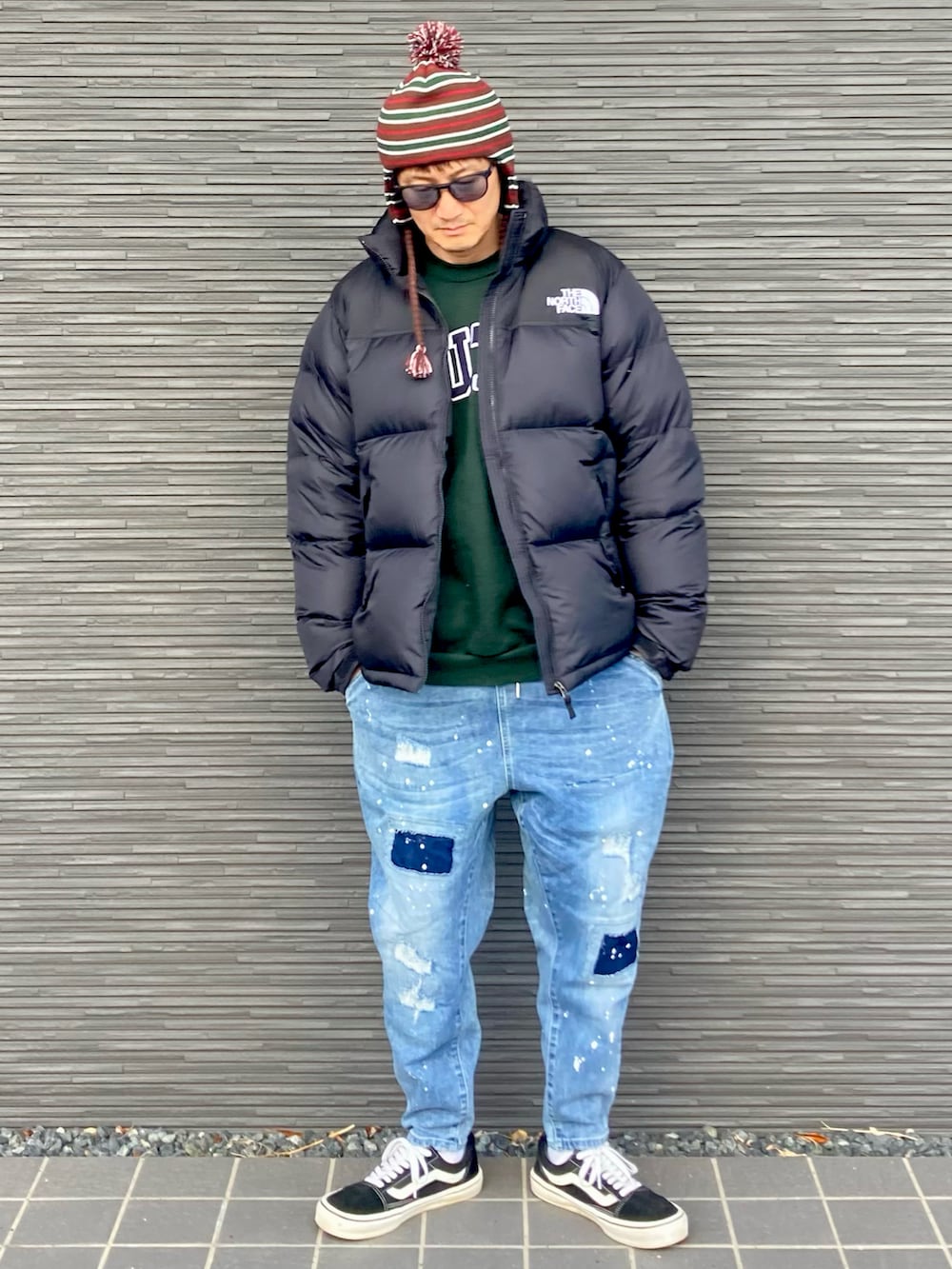 ブラック系のダウンジャケット/コート、グリーン系のスウェット、ブルー系のデニムパンツを着用したメンズの冬コーディネートの2枚目の写真