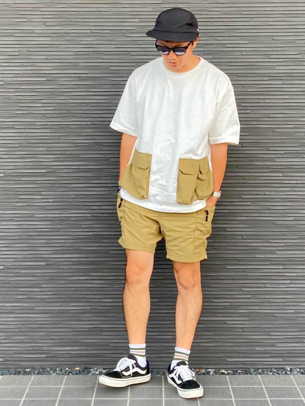 ホワイト系のTシャツ/カットソー、ベージュ系のその他パンツ、ブラック系のスニーカーを着用したメンズの夏コーディネートの2枚目の写真