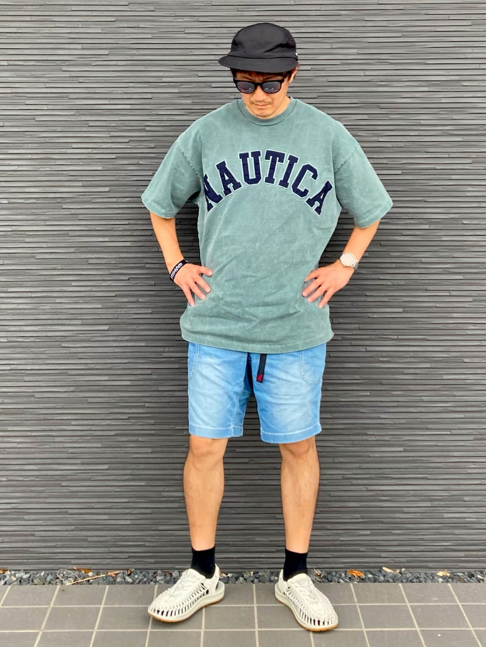 グリーン系のTシャツ/カットソー、ブルー系のデニムパンツ、ホワイト系のサンダルを着用したメンズの夏コーディネートの4枚目の写真