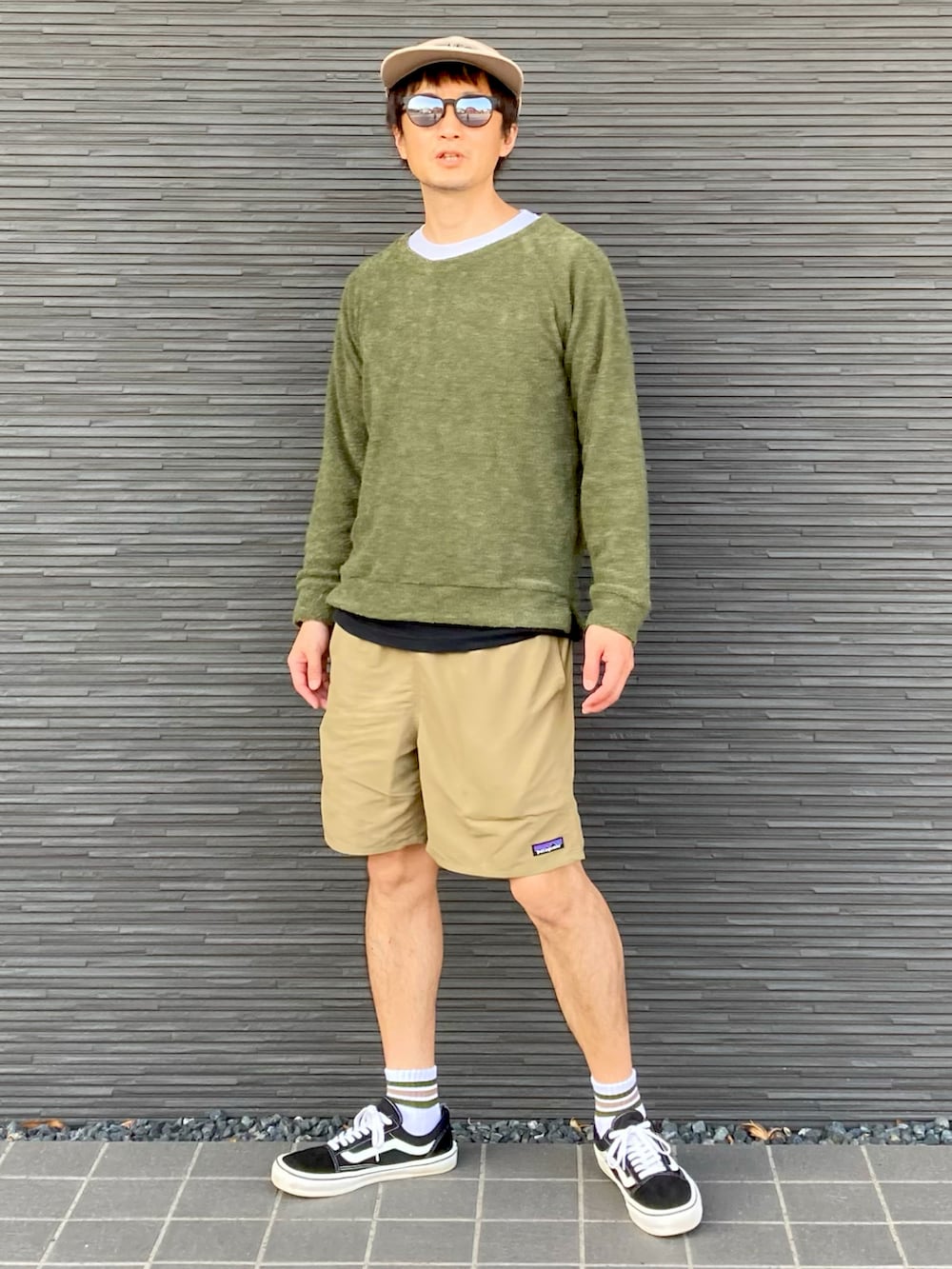 グリーン系のニット/セーター、ホワイト系のTシャツ/カットソー、ブラック系のTシャツ/カットソーを着用したメンズの春コーディネートの2枚目の写真