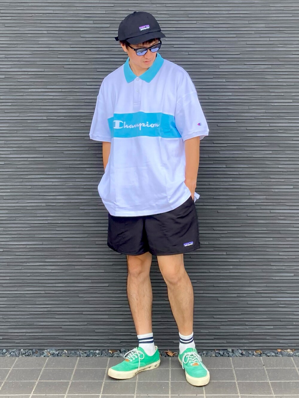 ホワイト系のポロシャツ、ブラック系のその他パンツ、グリーン系のスニーカーを着用したメンズの夏コーディネートの2枚目の写真