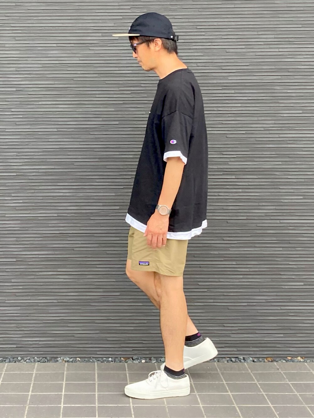 ブラック系のTシャツ/カットソー、ベージュ系のその他パンツ、ホワイト系のスニーカーを着用したメンズの夏コーディネートの3枚目の写真