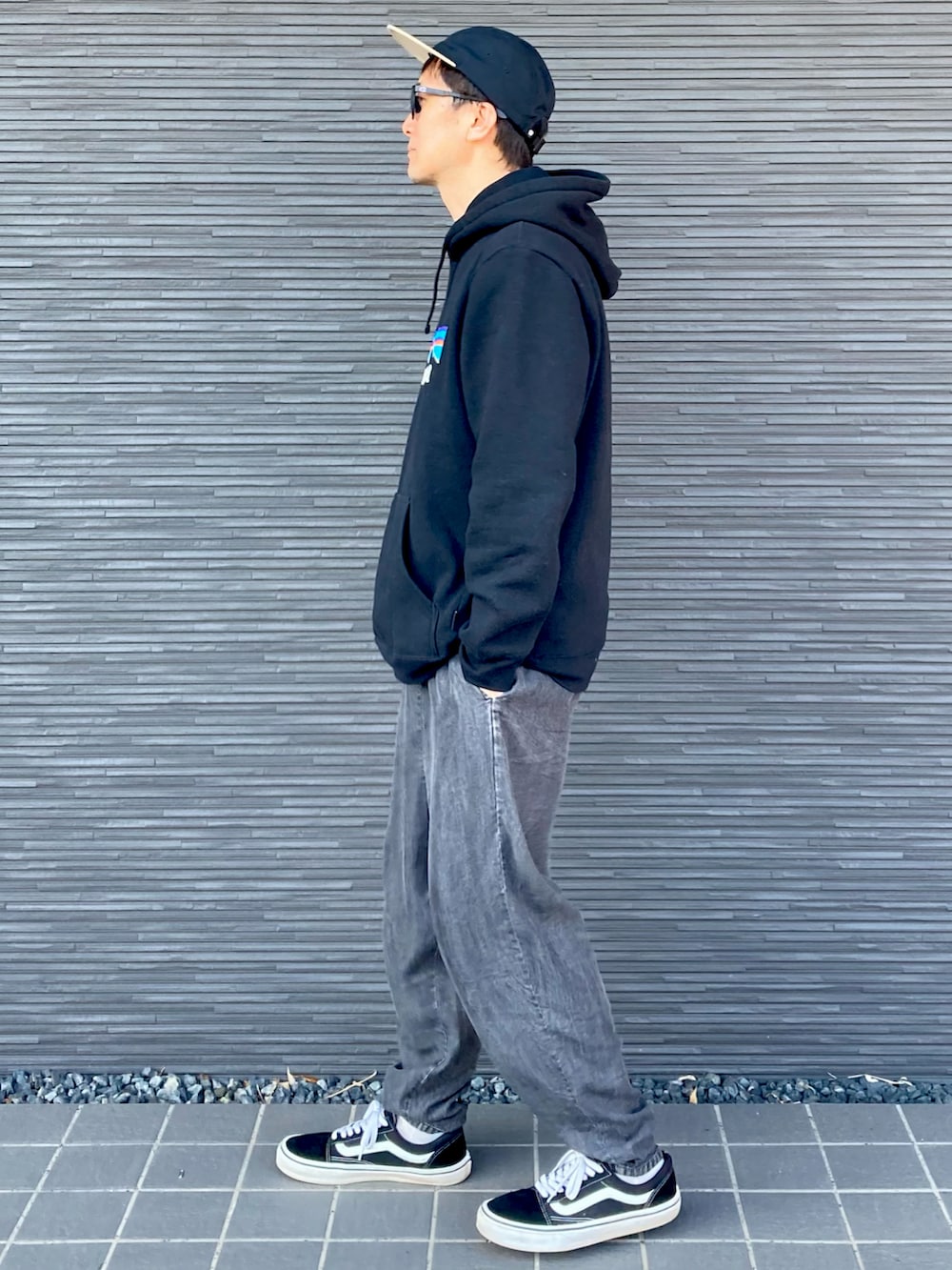 ブラック系のパーカー、ブラック系のその他パンツ、ブラック系のスニーカーを着用したメンズの春コーディネートの2枚目の写真