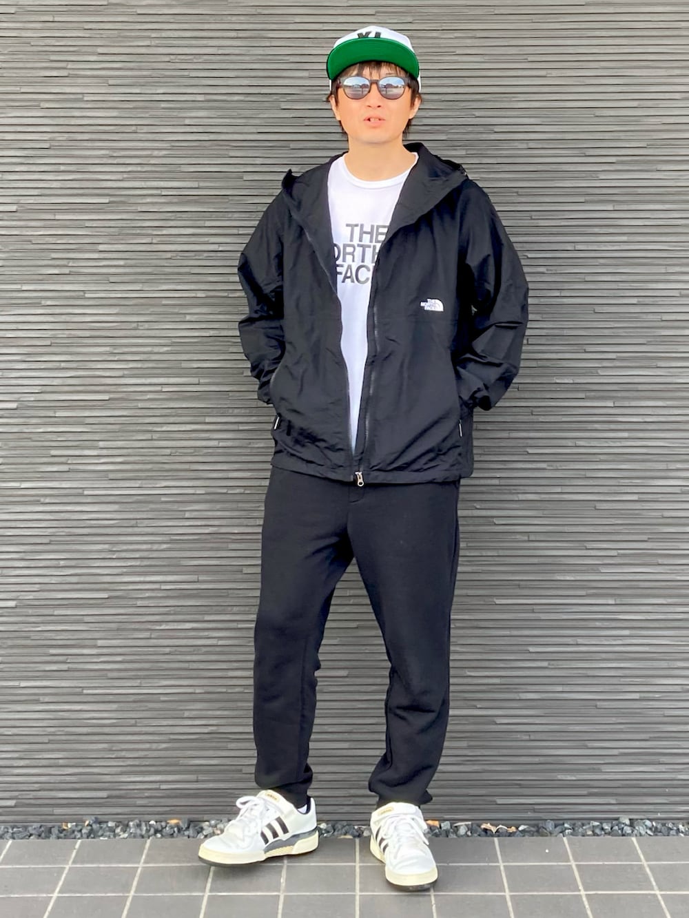 ブラック系のナイロンジャケット、ホワイト系のTシャツ/カットソー、ブラック系のスウェットパンツを着用したメンズの春コーディネートの2枚目の写真