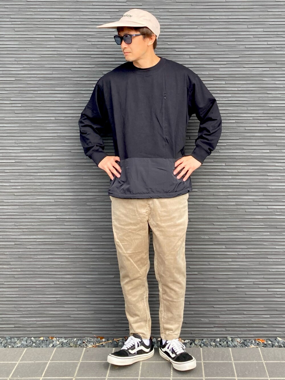 ブラック系のトップス、ベージュ系のその他パンツ、ブラック系のスニーカーを着用したメンズの秋コーディネートの3枚目の写真