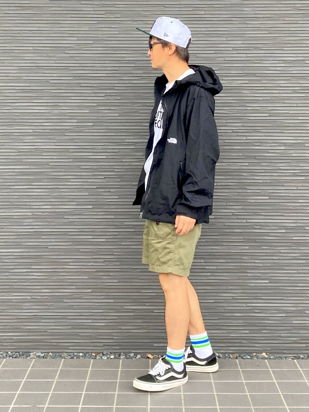 ブラック系のナイロンジャケット、ホワイト系のTシャツ/カットソー、グリーン系のその他パンツを着用したメンズの秋コーディネートの2枚目の写真