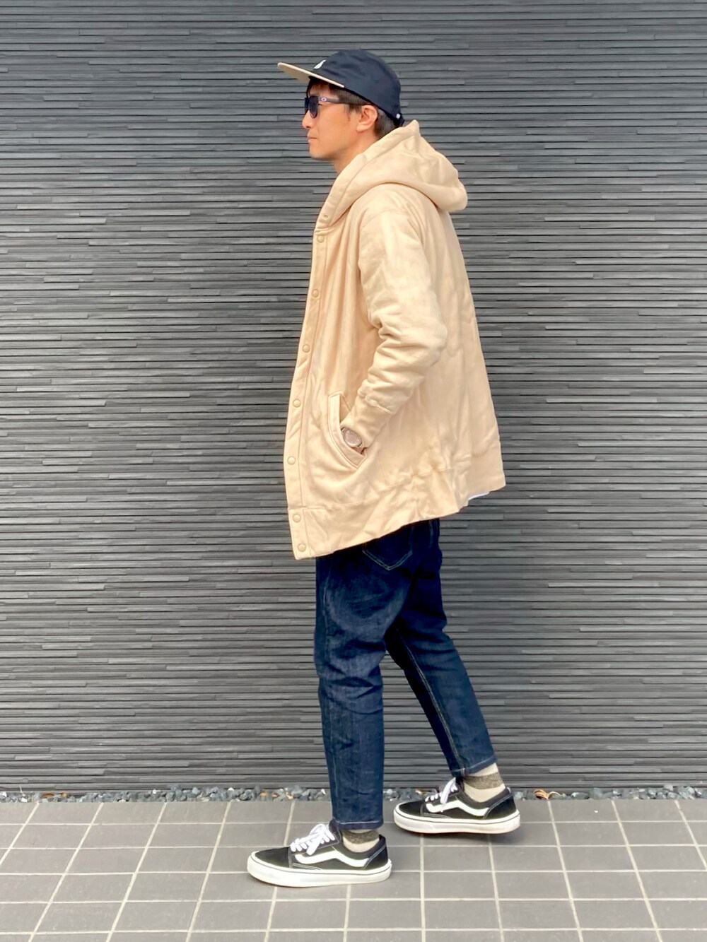 ベージュ系のパーカー、ブラック系のTシャツ/カットソー、ブルー系のデニムパンツを着用したメンズの秋コーディネートの2枚目の写真