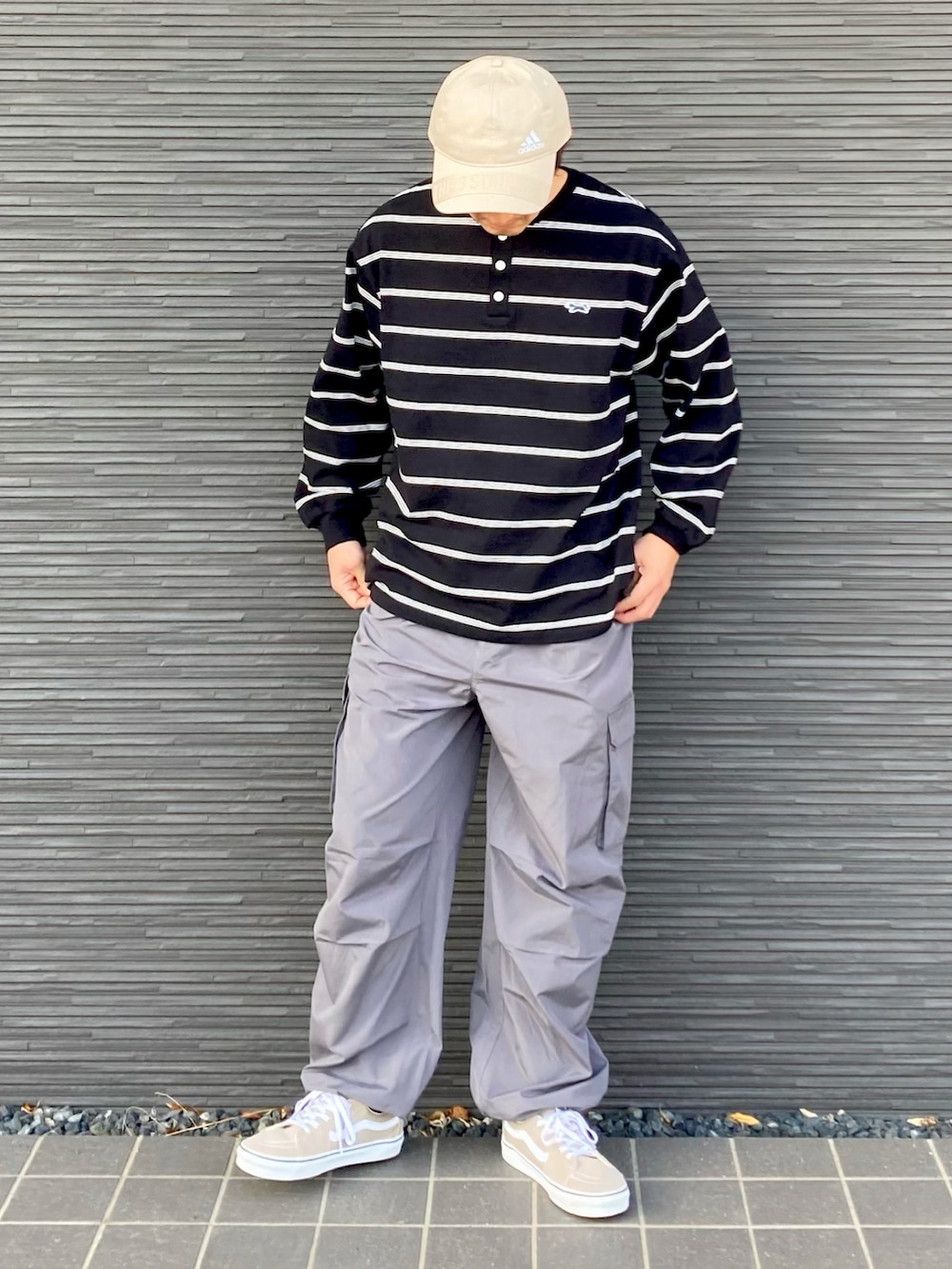 ブラック系のTシャツ/カットソー、グレー系のパンツ、ベージュ系のスニーカーを着用したメンズの春コーディネートの3枚目の写真