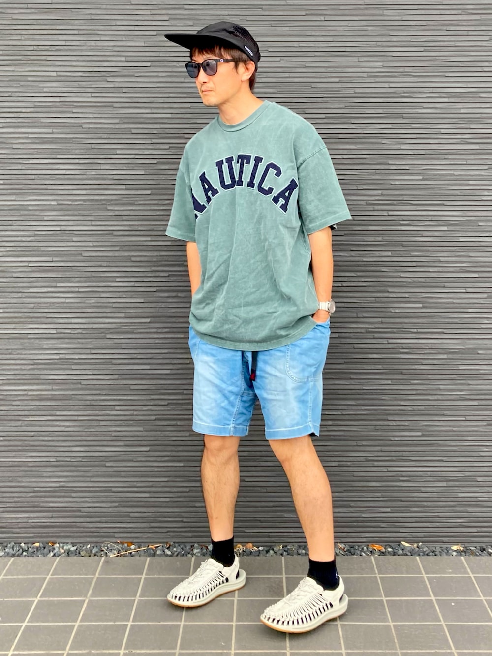 グリーン系のTシャツ/カットソー、ブルー系のデニムパンツ、ホワイト系のサンダルを着用したメンズの夏コーディネートの5枚目の写真