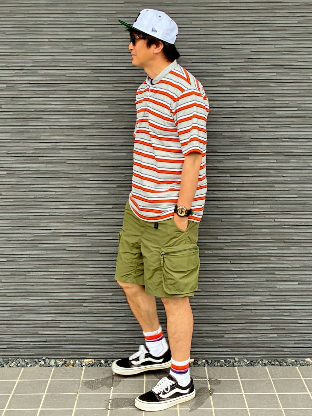 ブラック系のスニーカー、グレー系のTシャツ/カットソー、グリーン系のカーゴパンツを着用したメンズの夏コーディネートの3枚目の写真