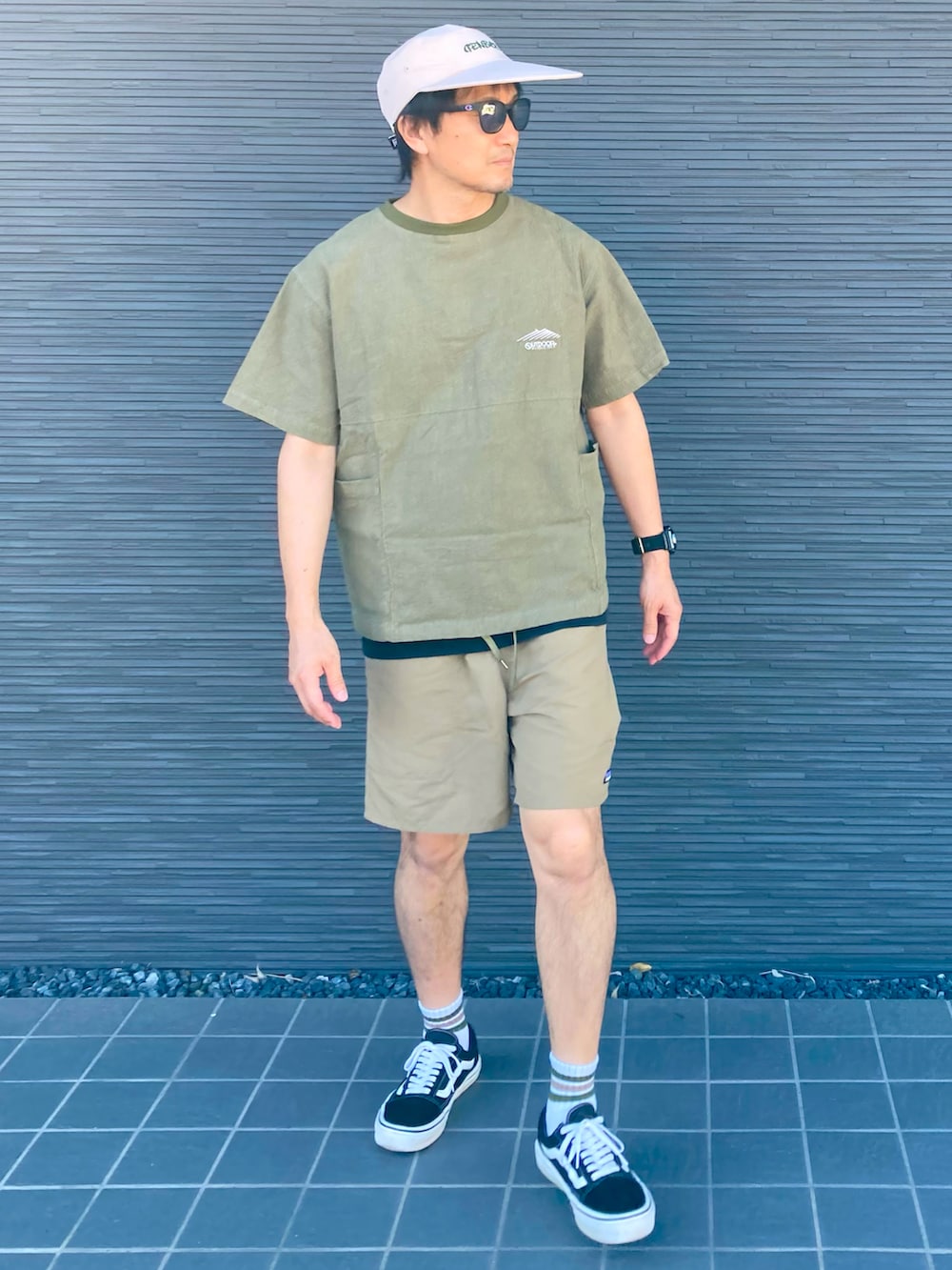 ブラック系のスニーカー、ベージュ系のその他パンツ、グリーン系のTシャツ/カットソーを着用したメンズの夏コーディネートの3枚目の写真