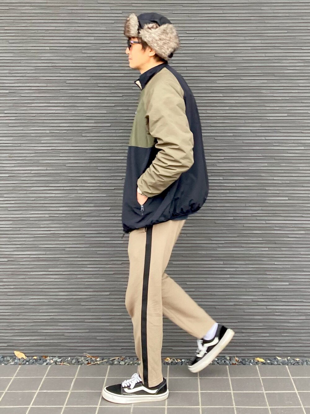 その他のナイロンジャケット、ベージュ系のパンツ、ブラック系のスニーカーを着用したメンズの冬コーディネートの3枚目の写真