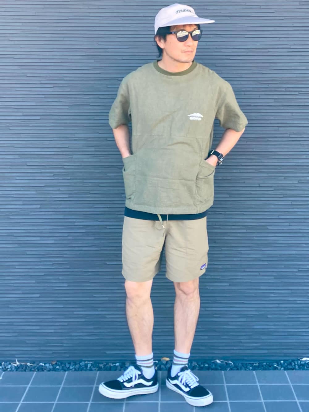 ブラック系のスニーカー、ベージュ系のその他パンツ、グリーン系のTシャツ/カットソーを着用したメンズの夏コーディネートの2枚目の写真