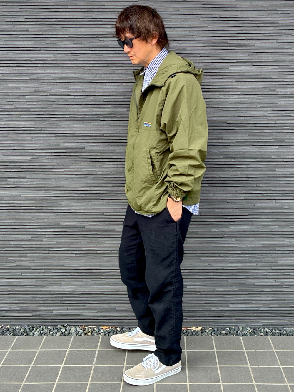 ブルー系のシャツ/ブラウス、グリーン系のナイロンジャケット、ブラック系のその他パンツを着用したメンズの春コーディネートの2枚目の写真