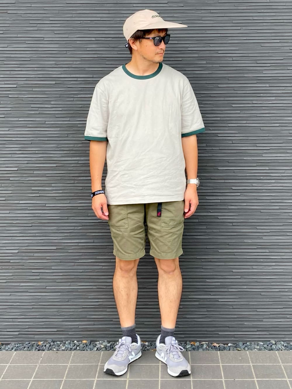 グレー系のトップス、グリーン系のカーゴパンツ、グレー系のスニーカーを着用したメンズの夏コーディネートの2枚目の写真