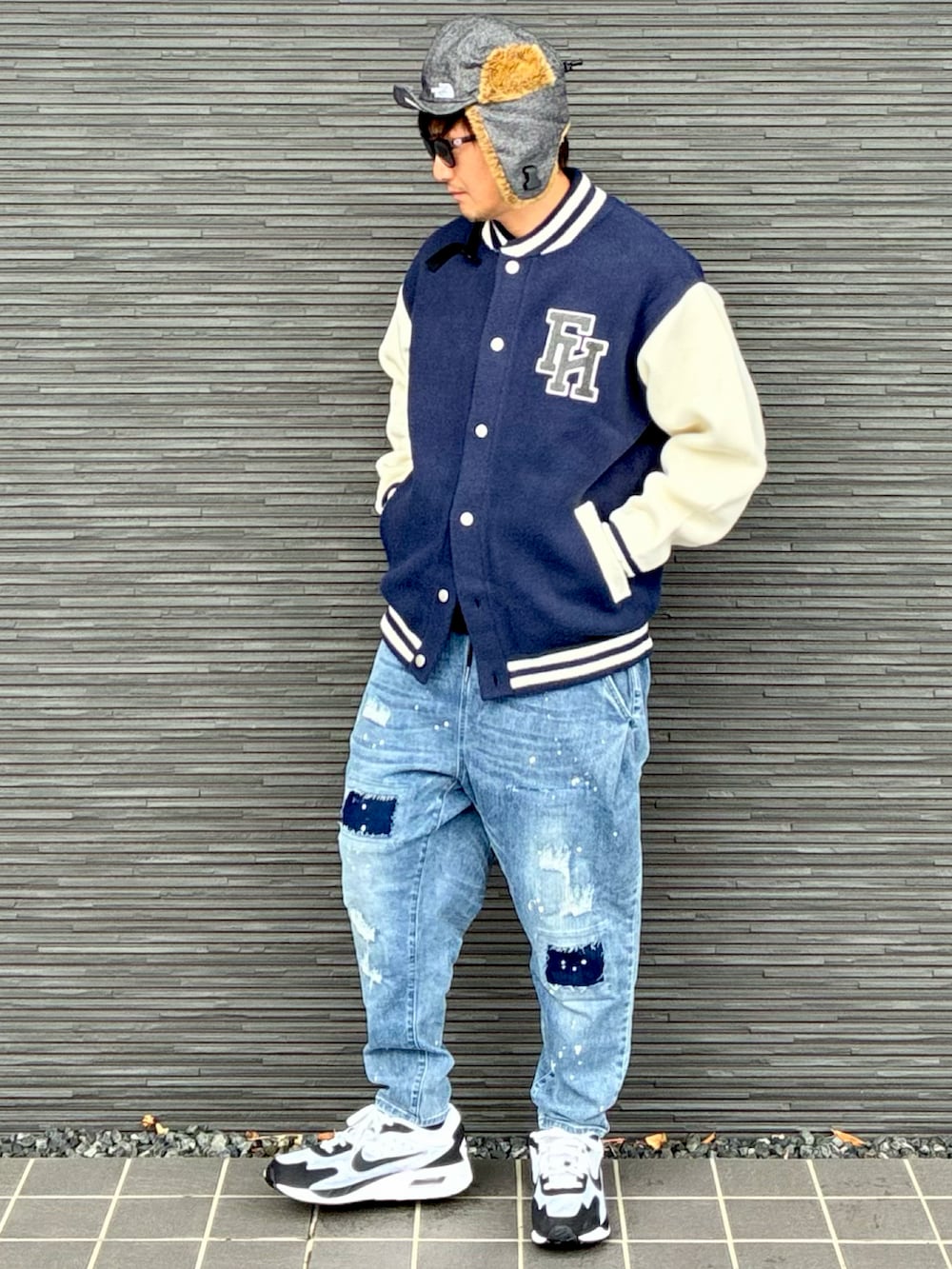 ブルー系のスタジャン、ブルー系のデニムパンツ、ホワイト系のスニーカーを着用したメンズの冬コーディネートの2枚目の写真