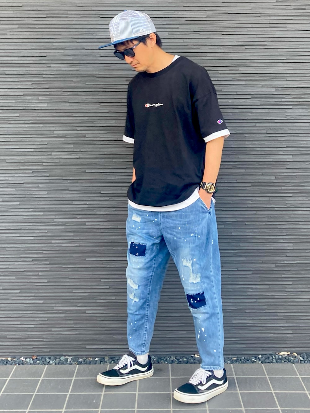 ブルー系のデニムパンツ、ブラック系のスニーカー、ブラック系のTシャツ/カットソーを着用したメンズの夏コーディネートの2枚目の写真