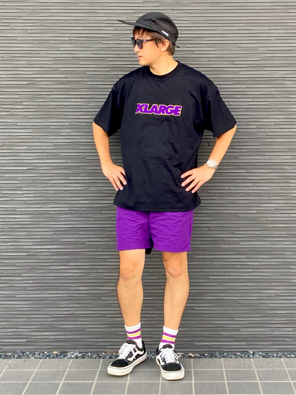 ブラック系のTシャツ/カットソー、パープル系のパンツ、ブラック系のスニーカーを着用したメンズの夏コーディネートの2枚目の写真