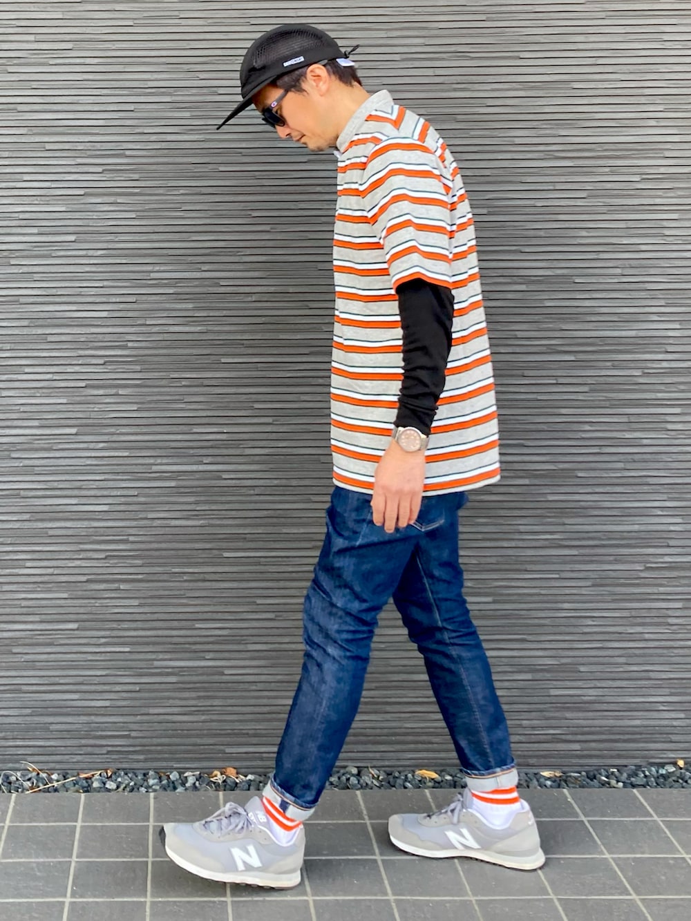 グレー系のTシャツ/カットソー、ブルー系のデニムパンツ、グレー系のスニーカーを着用したメンズの春コーディネートの2枚目の写真