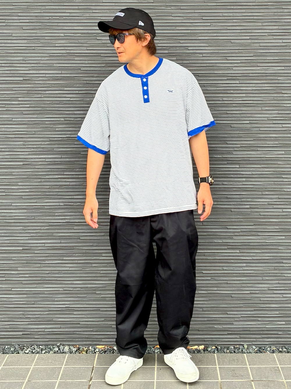 ブラック系のチノパンツ、ホワイト系のスニーカー、ブルー系のTシャツ/カットソーを着用したメンズの夏コーディネートの2枚目の写真
